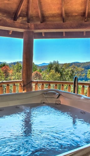 Hot tub on wooden deck gazebo overlooking forested mountains and valley in autumn
